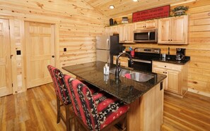 Enjoy cooking in this fully equipped kitchen with a central island, sink, and modern appliances.