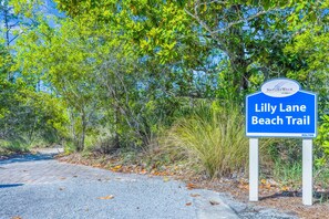 En skylt som visar vägen till vandringsleden vid Lilly Lane Beach.