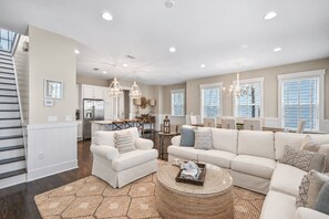 A spacious living area with a sofa set, a coffee table, and a dining table.