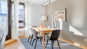 Ein moderner Essbereich mit einem Holztisch und Stühlen, einer Stehlampe und einem Gemälde an der Wand.