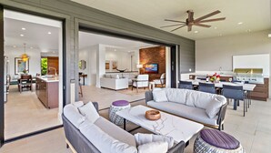 A modern open-plan living area with a kitchen, dining space, and a seating area with a sofa and coffee table.