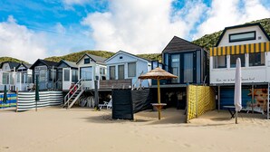 A row of beachside cabins with a sandy beach and a clear sky. - 1 bedroom gorgeous home in Vlissingen (Vlissingen)