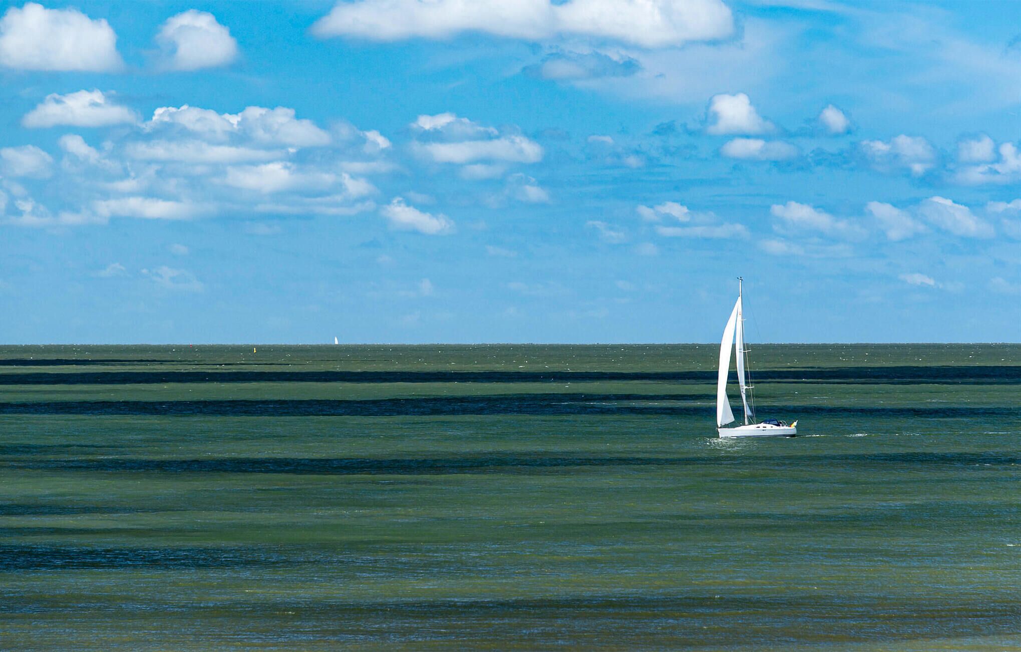 Un velero en un mar tranquilo con cielo despejado.