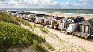 A row of beachside mobile homes with sandy surroundings and a view of the sea. - 1 bedroom gorgeous home in Vlissingen (Vlissingen)