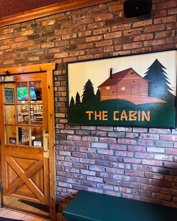 Enter THE CABIN, featuring a rustic door with a glass panel and a view into the interior.