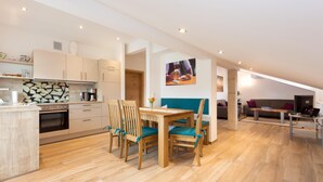 A modern kitchen with wooden cabinets and a dining area with a table and chairs. - Ferienwohnung Nummer 2 im Zweiten Stock (Übersee)