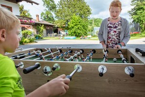 A wooden foosball table with multiple players and a ball. - Apartment No. 1 with a mountain view, 57 m², large triple bedroom, and a new bathroom (Übersee)