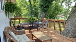 A covered outdoor deck with wicker furniture, a table, and chairs. - Comfortable and relaxing Cottage getaway. (Saint Marys)