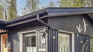 A cabin with a dark exterior, numbered 3, featuring large windows and a small porch.