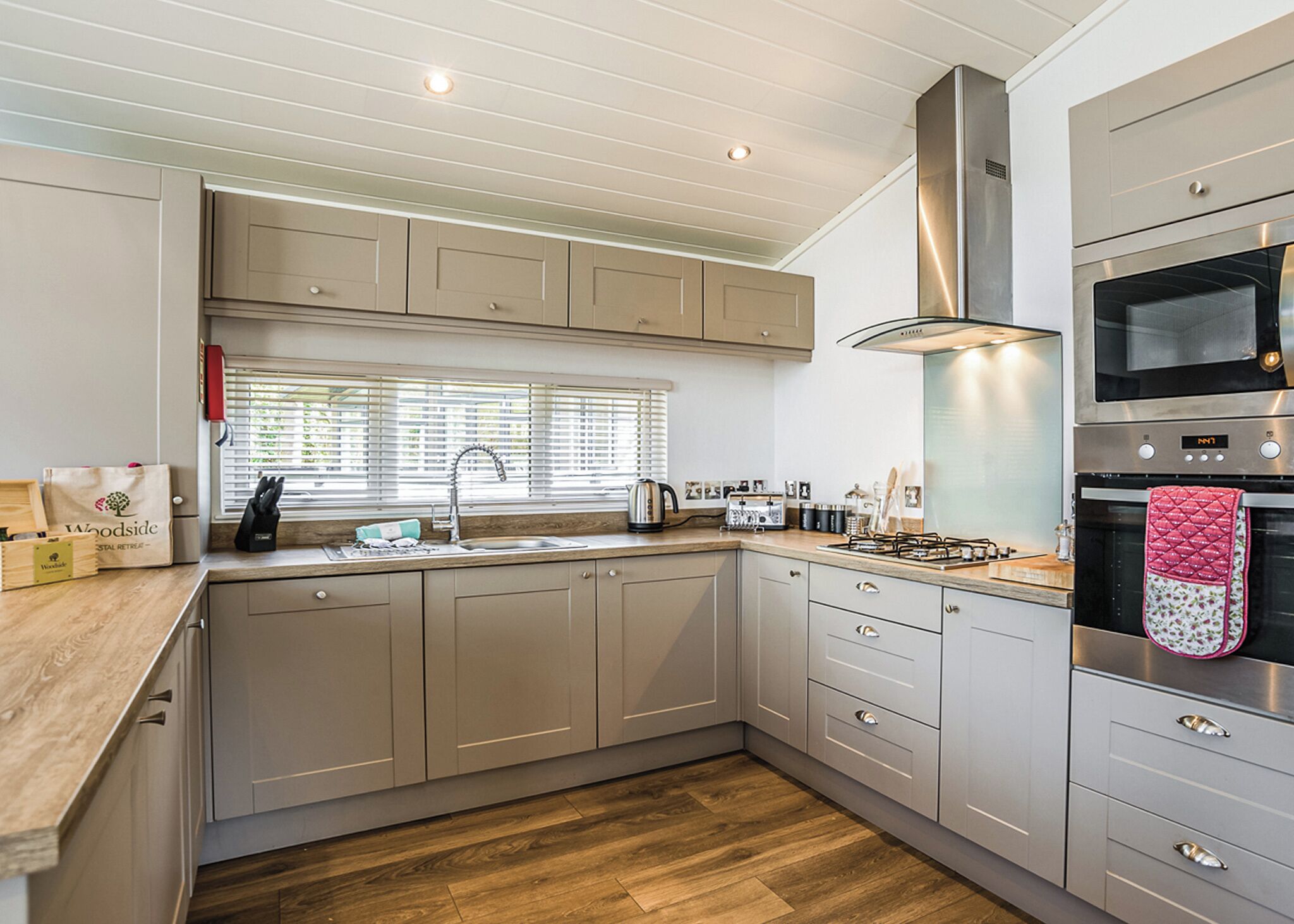A modern kitchen with a built-in oven, microwave, and gas stove.