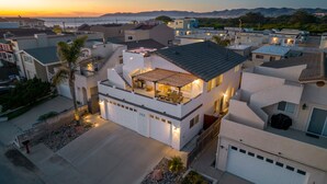 Uma casa moderna de dois andares com telhado plano, varanda com área de estar ao ar livre e garagem.