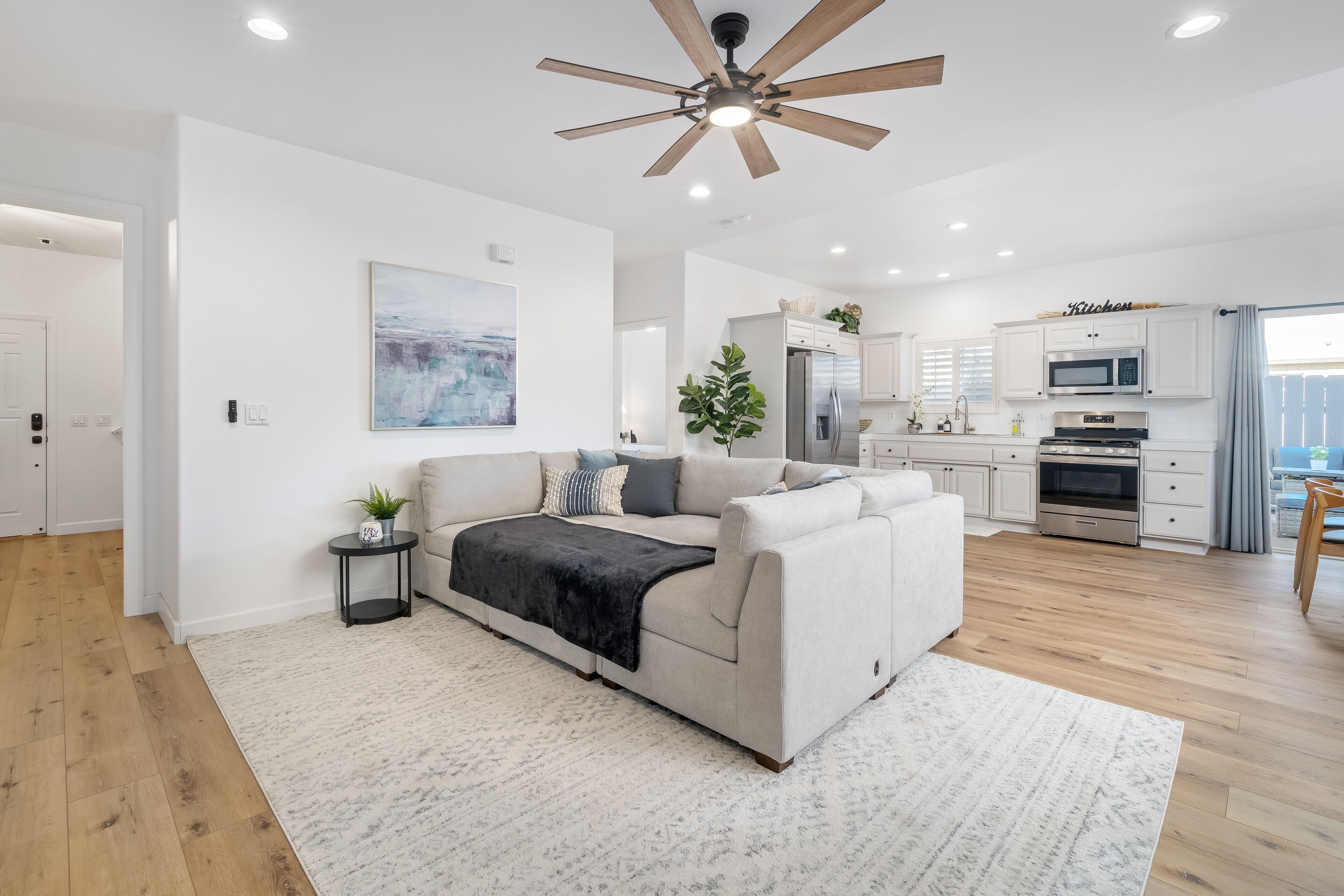 A modern living room with a sofa, a coffee table, and a ceiling fan.