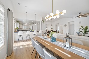 Une cuisine moderne avec des armoires blanches, un plan de travail en bois et des luminaires suspendus.