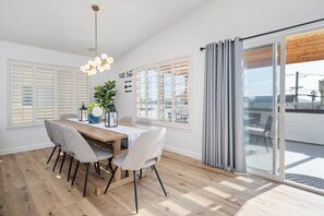 Enjoy meals in this dining area with a table for four, surrounded by a large window and a potted plant.