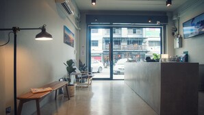 Un área de recepción con un banco, plantas en macetas y un mostrador.
