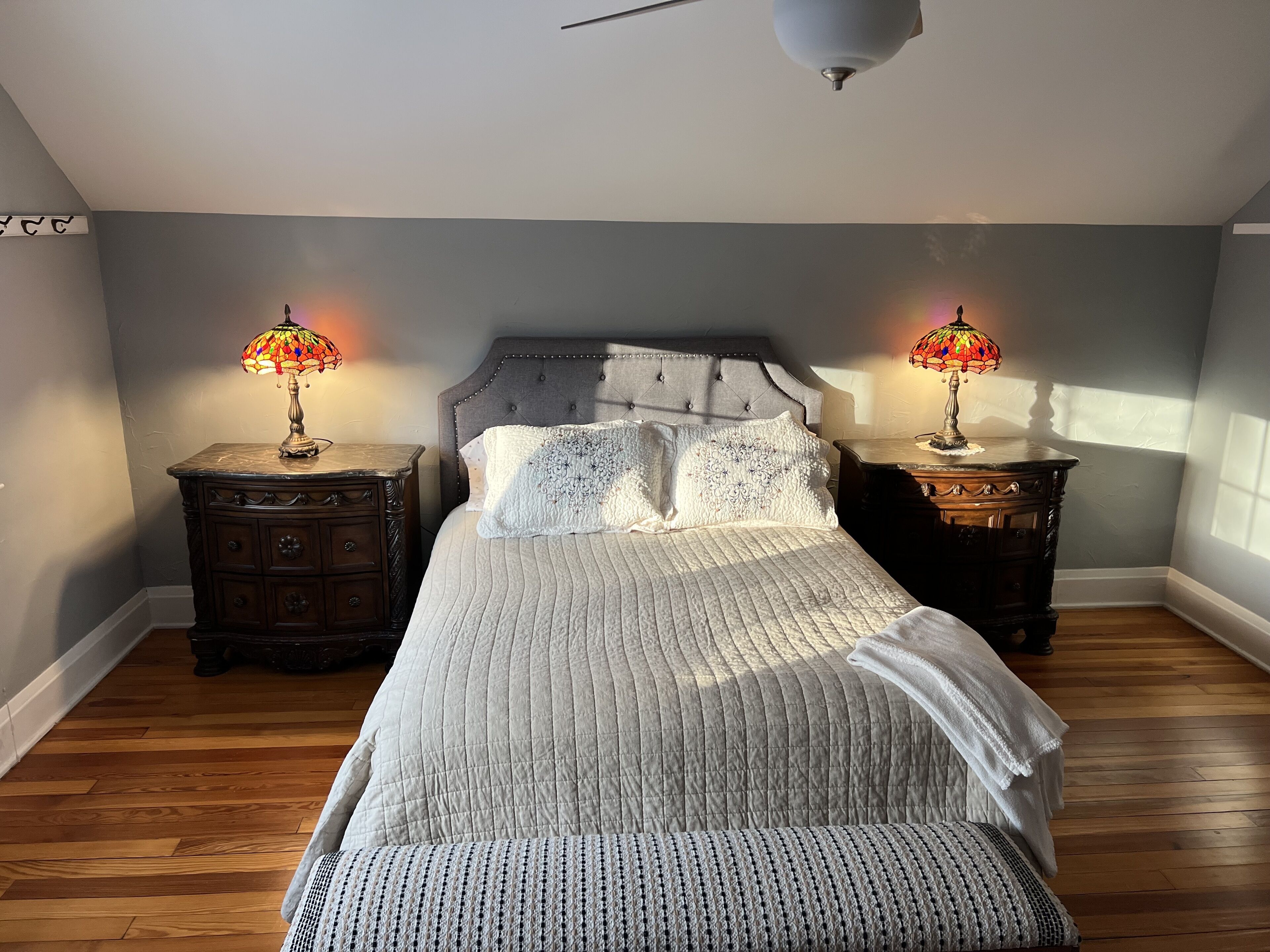 A bedroom with a large bed, two nightstands, and two lamps.