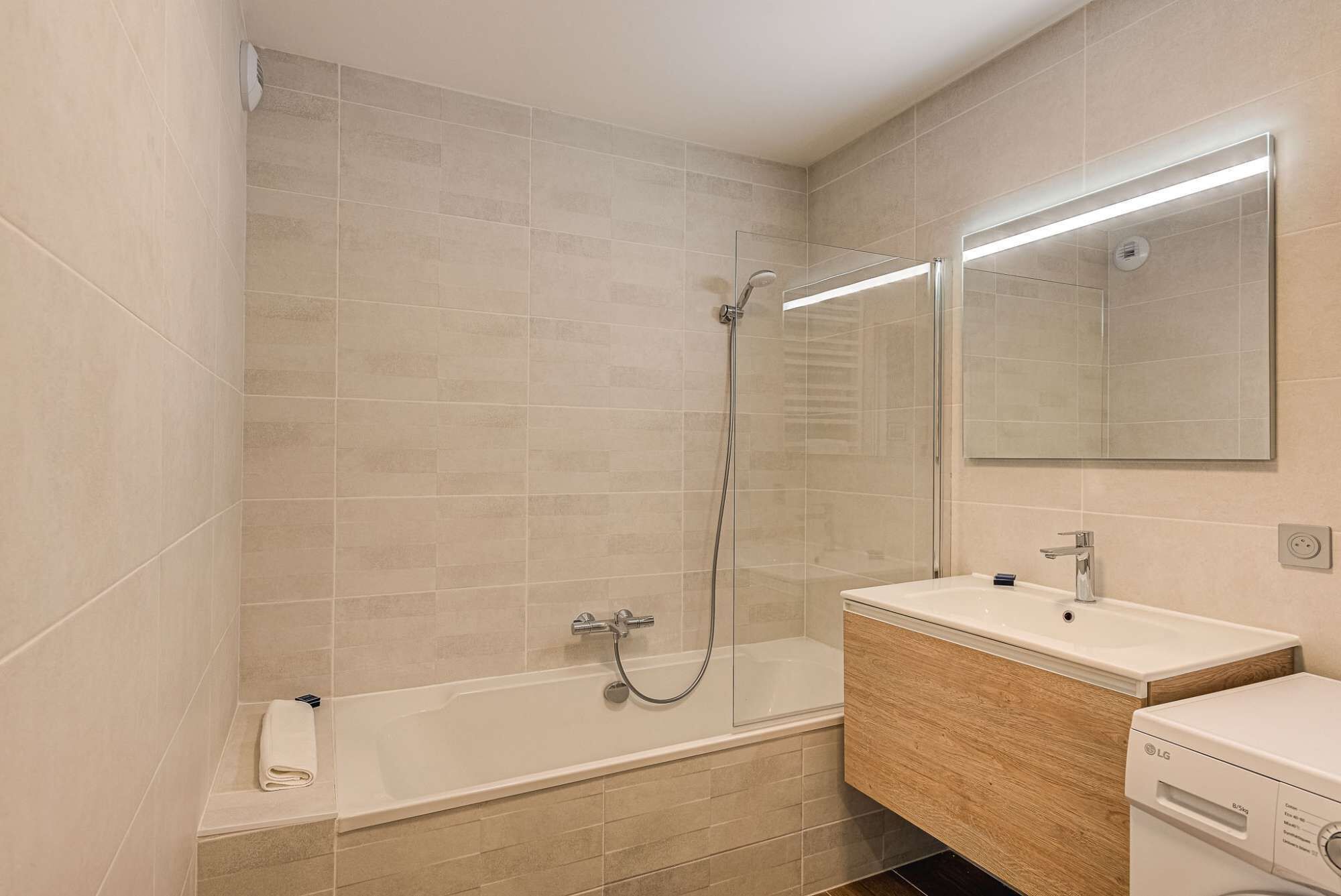 Ein modernes Badezimmer mit Badewanne, Dusche und Waschbecken.