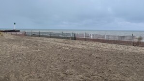 A beach with a wooden fence and a lighthouse in the distance. - Parkhill / GrandBend - Spanish Style Private Acerage property (Parkhill)