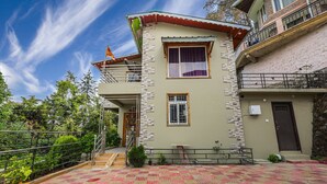 A two-story building with a balcony, a flag, and a tiled patio area.