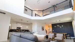 Een ruime woonkamer met een moderne keuken, een eethoek en een balkon.