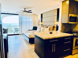 A modern kitchen with a large island, built-in microwave, and stainless steel appliances.