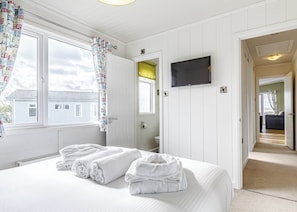 Ein Hotelzimmer mit Bett, Fernseher, Badezimmer und Blick nach draußen.