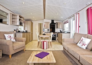 A modern living room with a dining area, wooden furniture, and a kitchen in the background.