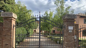 A gated entrance with a brick wall and a metal gate. - Vacation house with pool and garden (Campiglia Marittima)