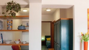 A narrow hallway with a bed, a wardrobe, and shelves with decorative items. - Apollo's Terraces Beach apartments less than 20 m from the sea!Sirocco (Marinella di Selinunte)