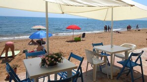 A beachside café with outdoor seating, umbrellas, and a view of the sea. - Apollo's Terraces Beach apartments less than 20 m from the sea!Sirocco (Marinella di Selinunte)