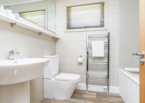 Ein modernes Badezimmer mit Waschbecken, Toilette und Handtuchhalter.