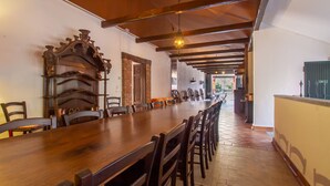 A long wooden dining table with chairs, a brick wall, and a wooden ceiling. - Villa in Piedmont with private pool in beautiful vineyard of Tenuta CostaRossa (Piemonte)