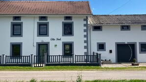 Ein zweistöckiges Gebäude mit Ziegeldach, einem Schild mit der Aufschrift 'Gîte Noel' und einem eingenetzten Eingang.