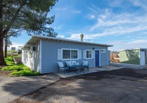 A small, single-story mobile home with a porch and a blue door.