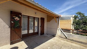 Un edificio con puerta de madera, una ventana y un pequeño porche.