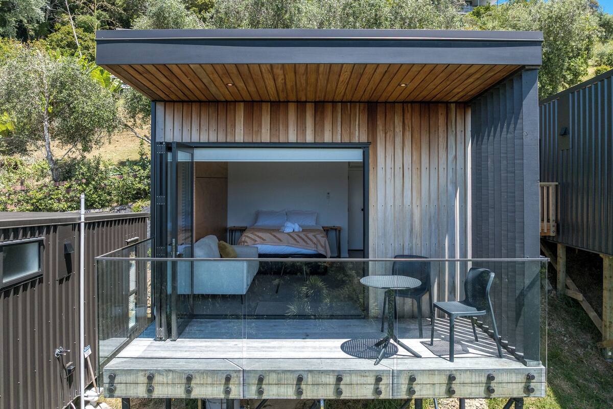 A modern, compact cabin with a balcony, a bed, and a small seating area.