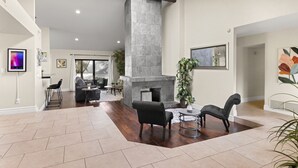 A spacious living area with a fireplace, comfortable seating, and a dining area with a view. - Perfectly Located Spacious Home with Heated Pool (Scottsdale)