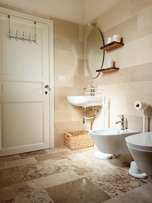 A bathroom with a white door, a sink, a toilet, a bathtub, and a mirror on the wall. - Giardino Frannicola (Maglie)