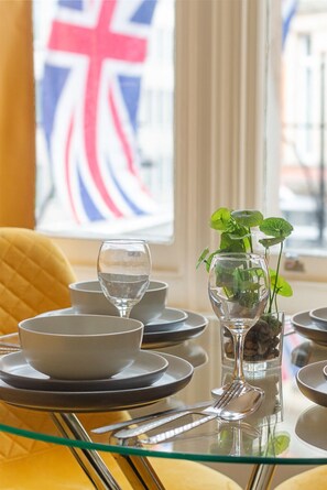 A dining table set with plates, bowls, and a glass of water. - Flat 6 Oxford · Apartment Oxford Street Bond Street Station. (Greater London)
