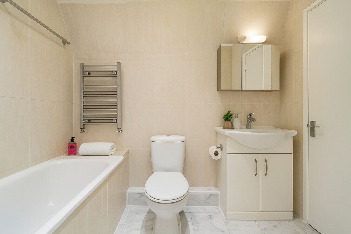 A bathroom with a bathtub, toilet, sink, and a towel rack.