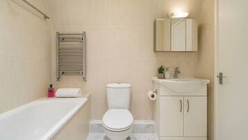 A bathroom with a bathtub, toilet, sink, and a towel rack.