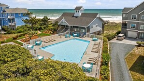 A pool area with lounge chairs and a view of the ocean. - Ocean Sounds: Spacious 7BR oceanview beach house in North Topsail with ocean views! (North Topsail Beach)