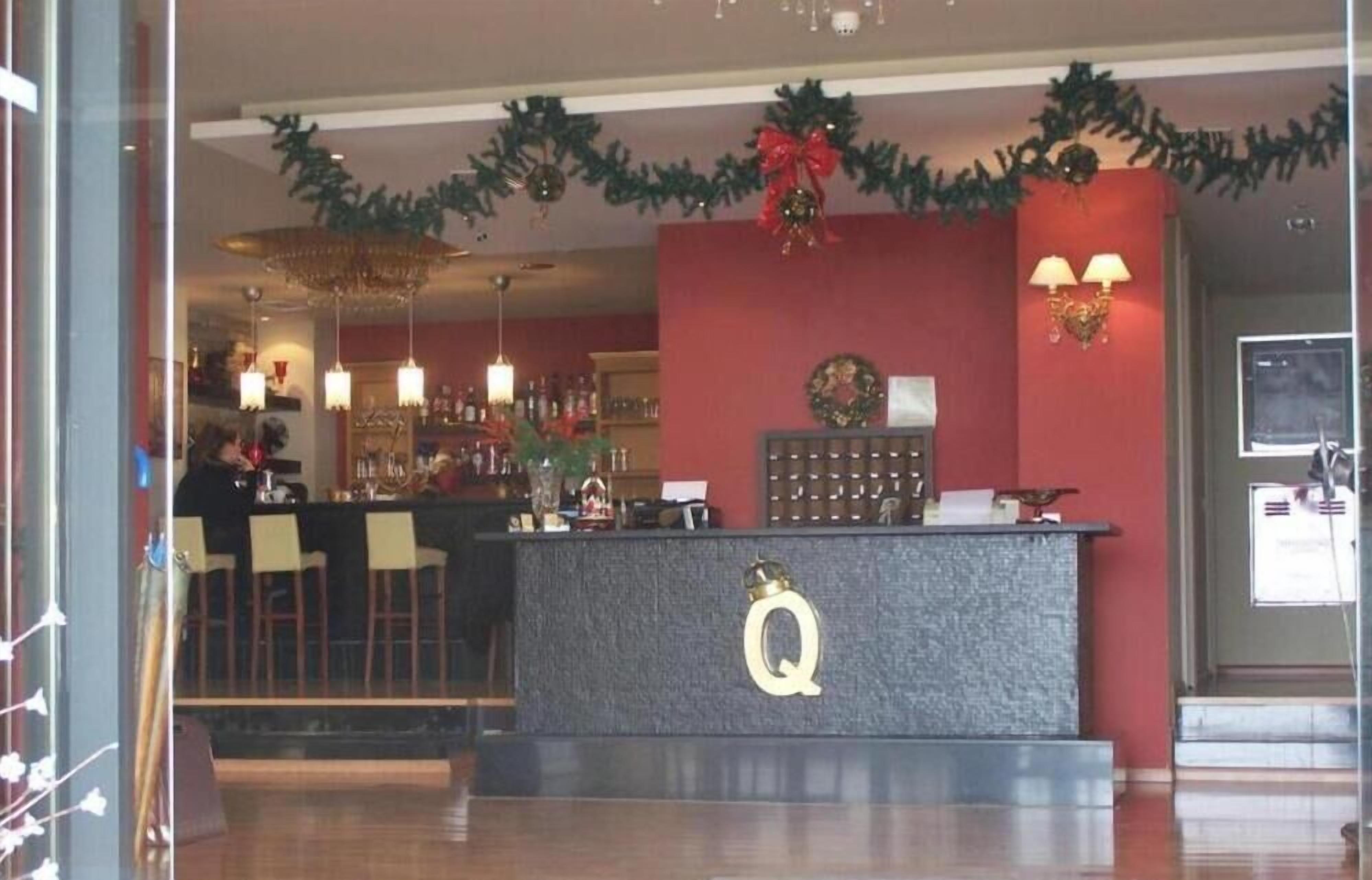 A bar area with a reception desk, a chandelier, and Christmas decorations.