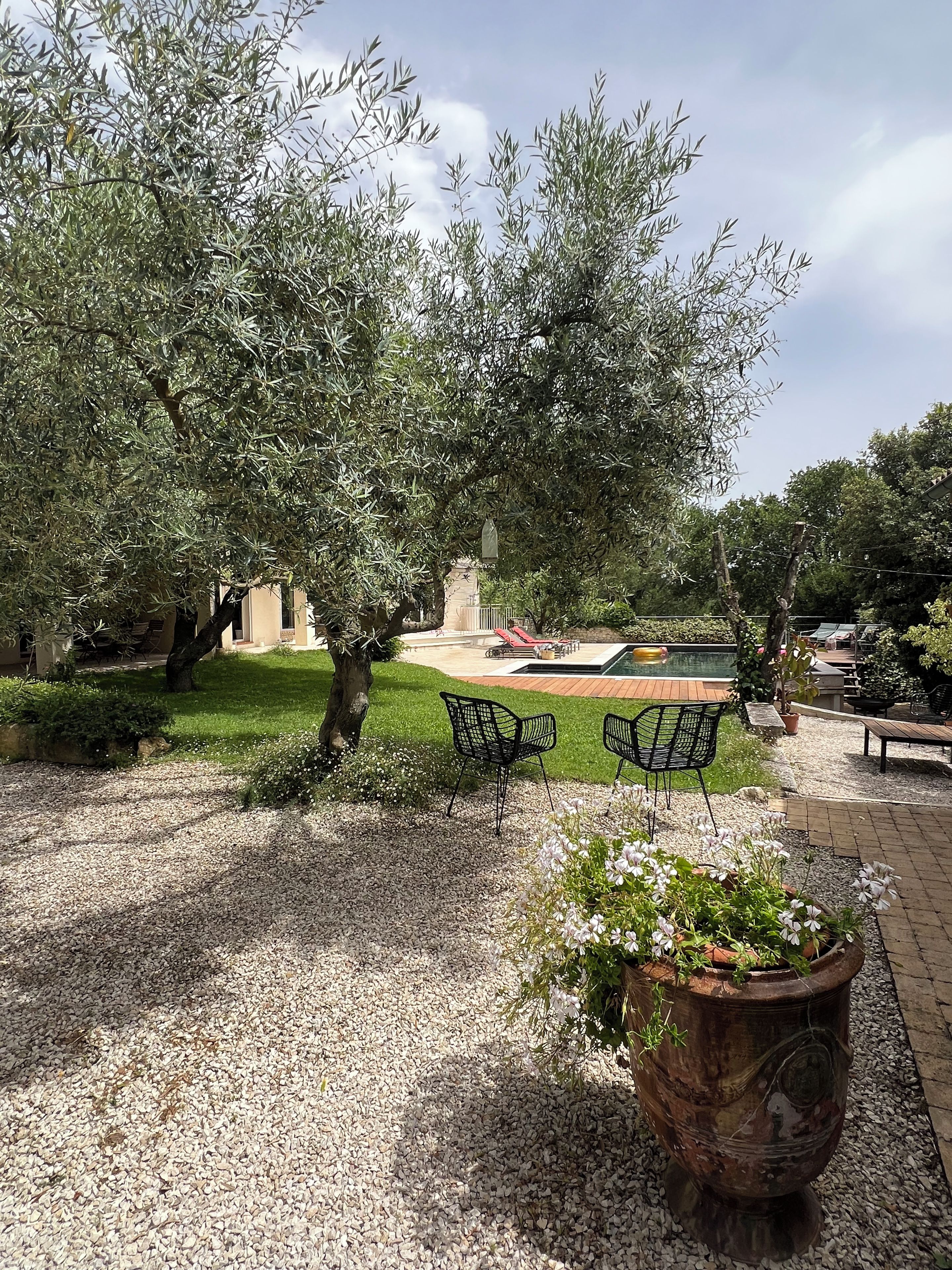 Un jardin avec une piscine, un espace salon extérieur et une pergola.