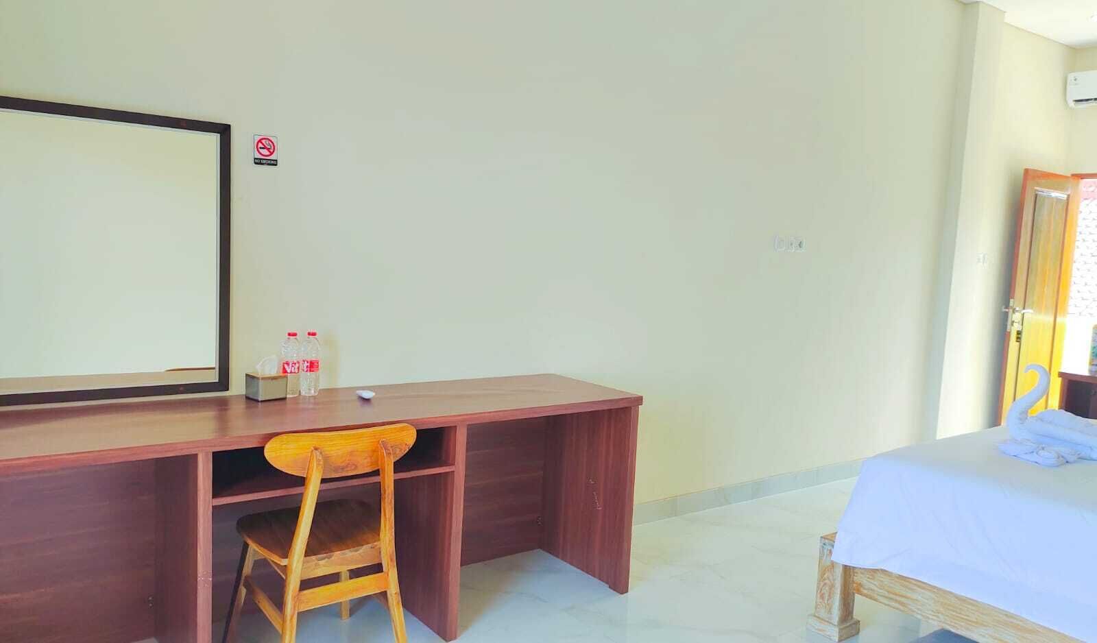 Una habitación con un escritorio de madera, una silla, una cama y una puerta.