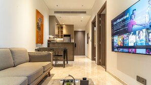 A modern living room with a sofa, a coffee table with a plant, and a TV displaying a 'Get Married' program. - The Rixx Skyline Apartment on 21st floor- Netflix, D1, pool, gym, sauna, jacuzzi (Thành phố Hồ Chí Minh)