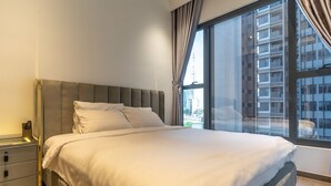 A neatly made bed in a hotel room with a large window offering a city view. - The Rixx Skyline Apartment on 21st floor- Netflix, D1, pool, gym, sauna, jacuzzi (Thành phố Hồ Chí Minh)