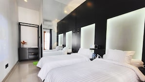 A modern hotel room with two beds, a large mirror, a small desk, and a plant. - Cabin15 -syariah (Blitar)