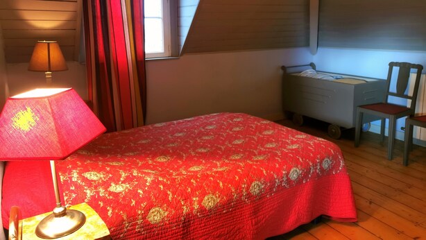 A bedroom with a bed, a desk, and a chair.