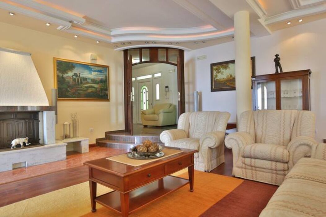 Una sala de estar con chimenea, un sofá, una mesa de centro y un cuadro en la pared.